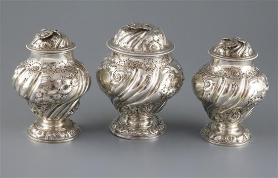 A pair of George II embossed silver tea caddies and a matching sugar box, Samuel Taylor, 32 oz.
